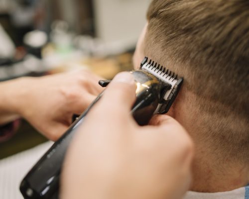 vista-del-primo-piano-dell-uomo-che-ottiene-un-taglio-di-capelli_23-2148506364